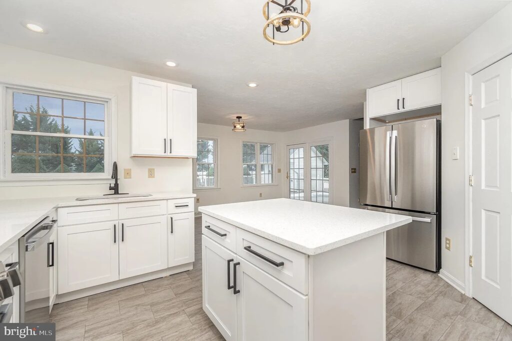 Kitchen white cabinets stainless steel steel appliances laminate flooring whit countertop